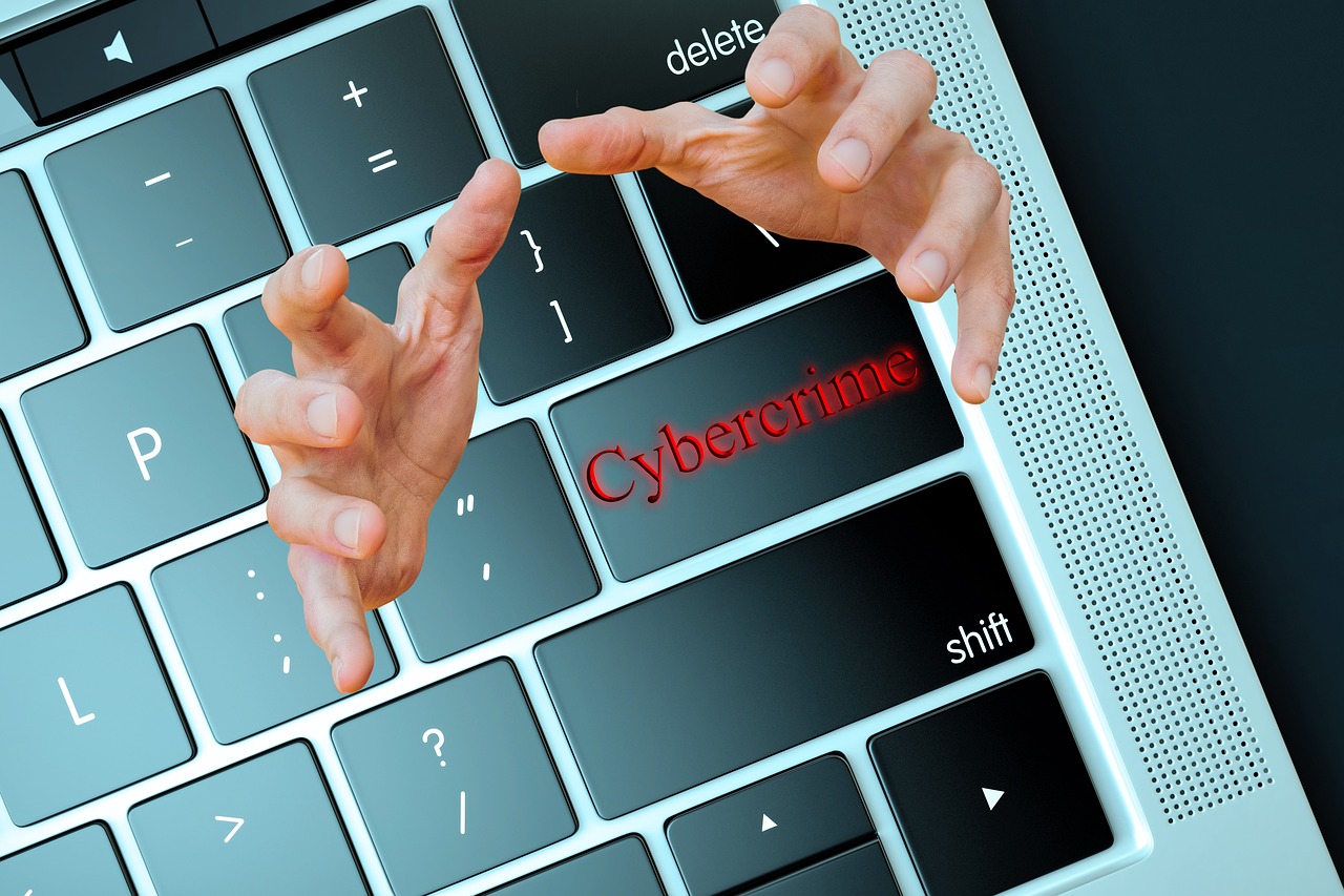 Hände greifen nach einer Tastatur mit der Taste Cybercrime, Symbolbild